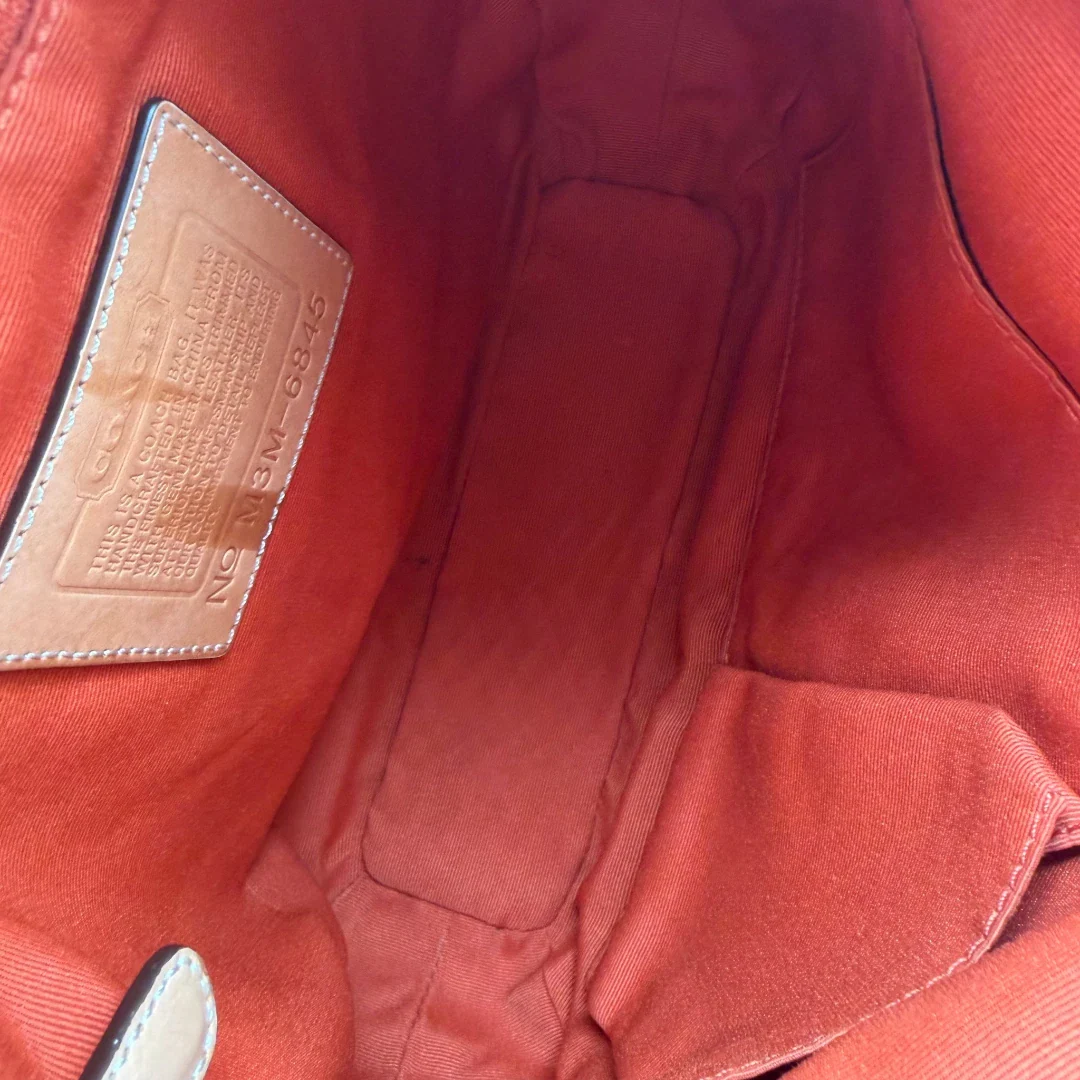 https://cdn.shopify.com/s/files/1/0564/9376/8855/files/Coach_Schultertasche_Jackie_Bucket_Signature_beige_14.webp?v=1782312193