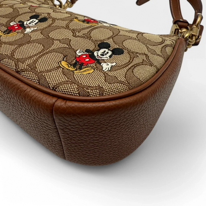 https://cdn.shopify.com/s/files/1/0564/9376/8855/files/Coach_x_Disney_Handtasche_Pochette_mit_Umhaengegurt_monogram_braun_vintage_luxury_handbag_2613.webp?v=1743622420