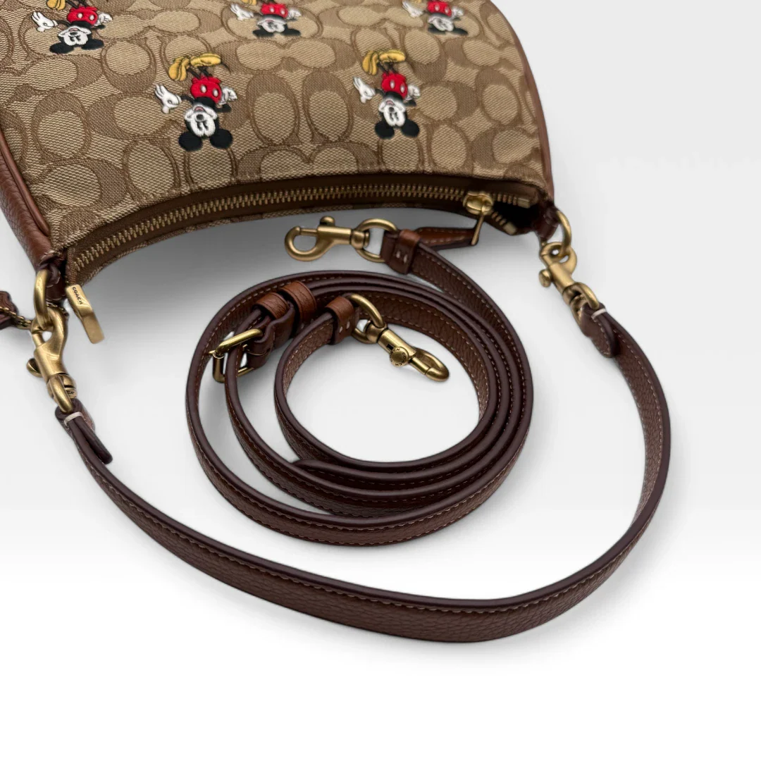 https://cdn.shopify.com/s/files/1/0564/9376/8855/files/Coach_x_Disney_Handtasche_Pochette_mit_Umhaengegurt_monogram_braun_vintage_luxury_handbag_2616.webp?v=1743622420