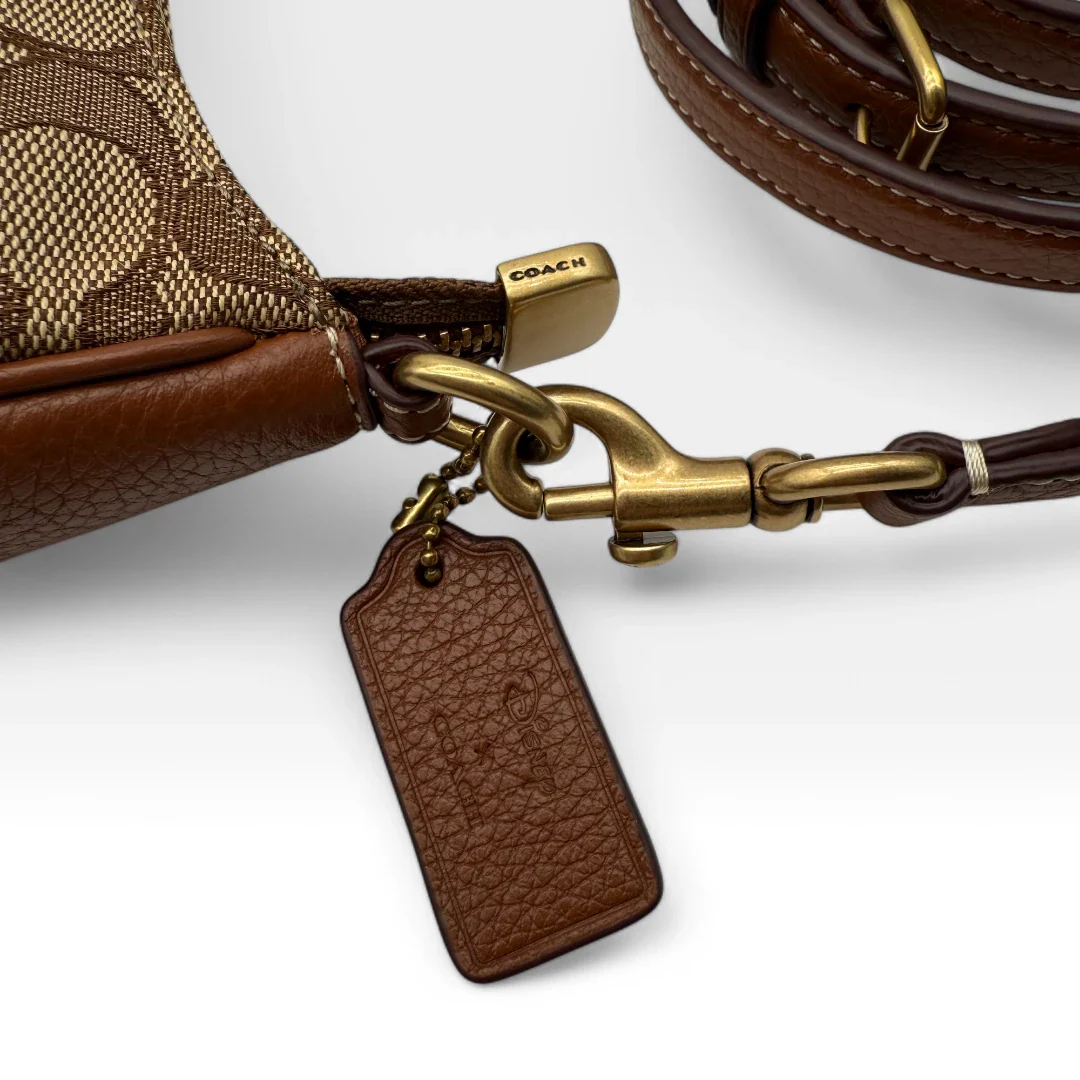 https://cdn.shopify.com/s/files/1/0564/9376/8855/files/Coach_x_Disney_Handtasche_Pochette_mit_Umhaengegurt_monogram_braun_vintage_luxury_handbag_2618.webp?v=1743622420