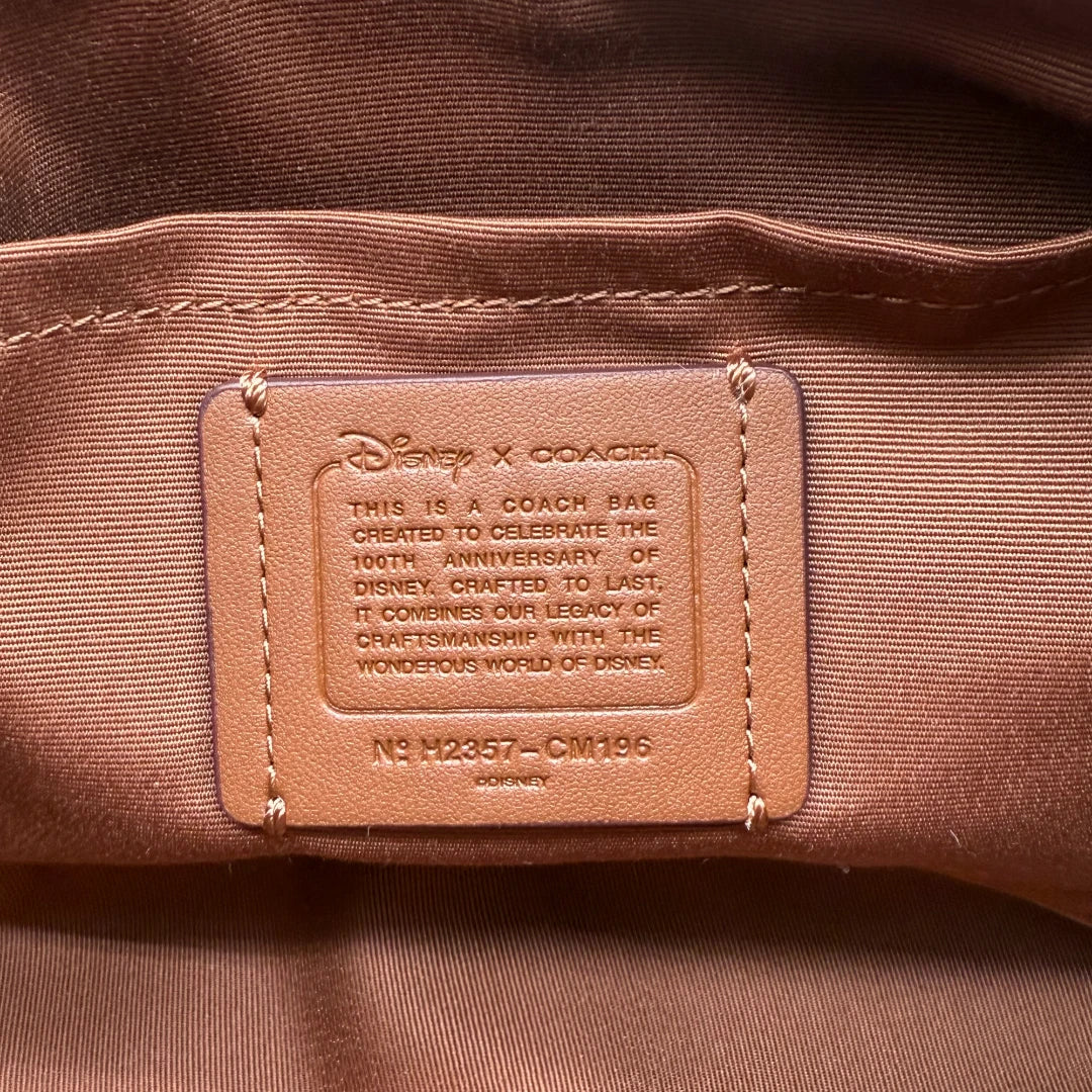 https://cdn.shopify.com/s/files/1/0564/9376/8855/files/Coach_x_Disney_Handtasche_Pochette_mit_Umhaengegurt_monogram_braun_vintage_luxury_handbag_2624.webp?v=1743622420