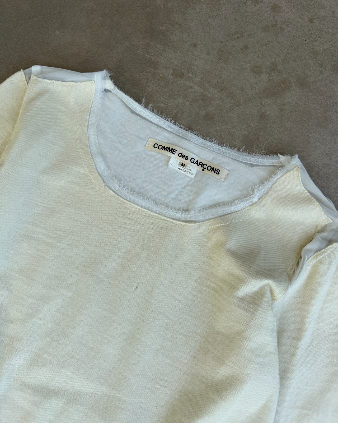 Comme des Garçons AW2012 Wool and Mesh Long Sleeve T-Shirt – M-on a concrete background