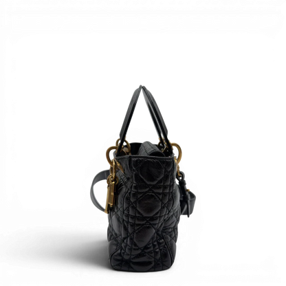 https://cdn.shopify.com/s/files/1/0564/9376/8855/files/Dior_Handtasche_Lady_Dior_medium_aus_Lammleder_schwarz_vintage8405.webp?v=1780486575