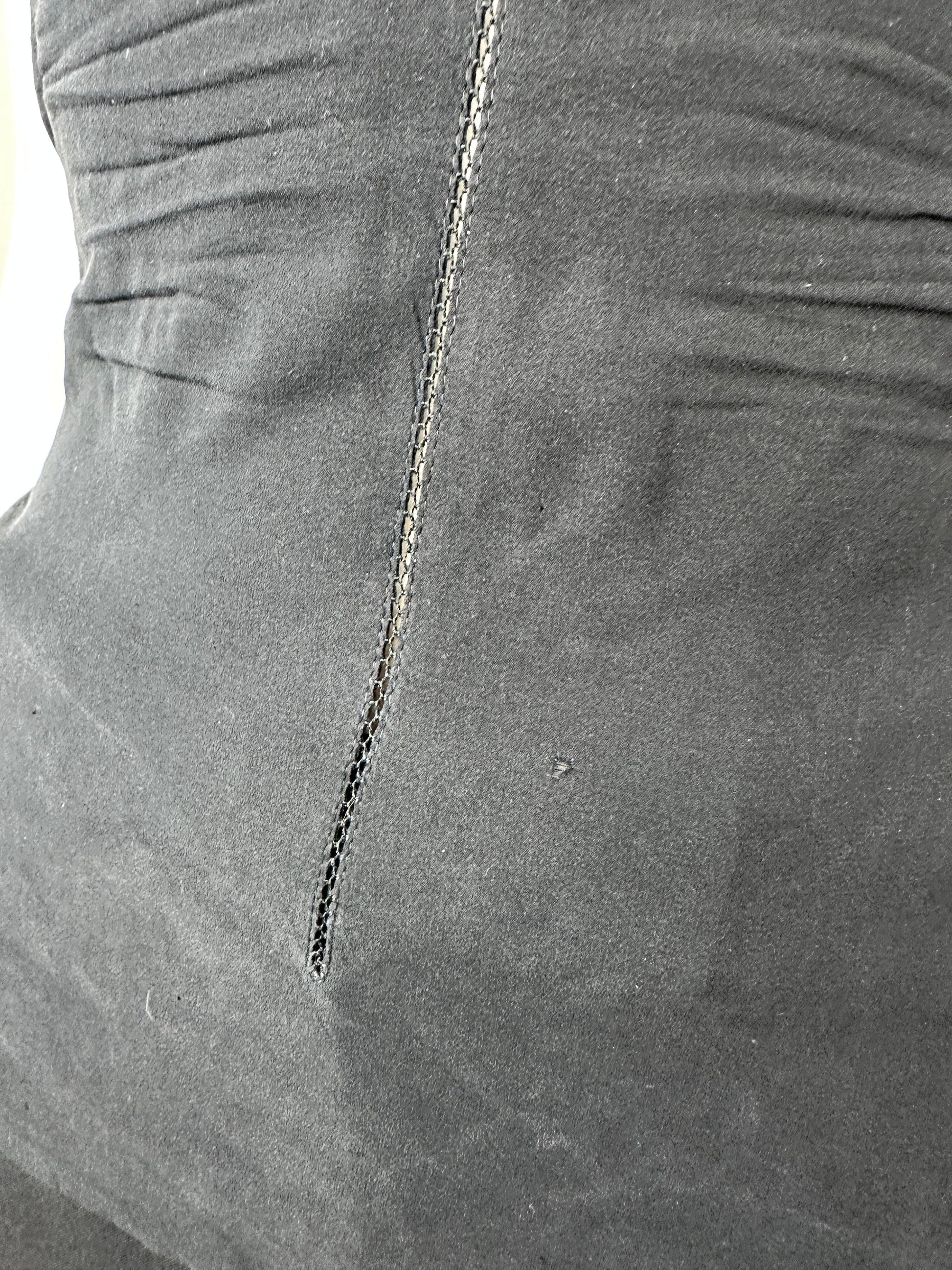 Close-up of a dark gray fabric surface with a visible seam and stitched detail.