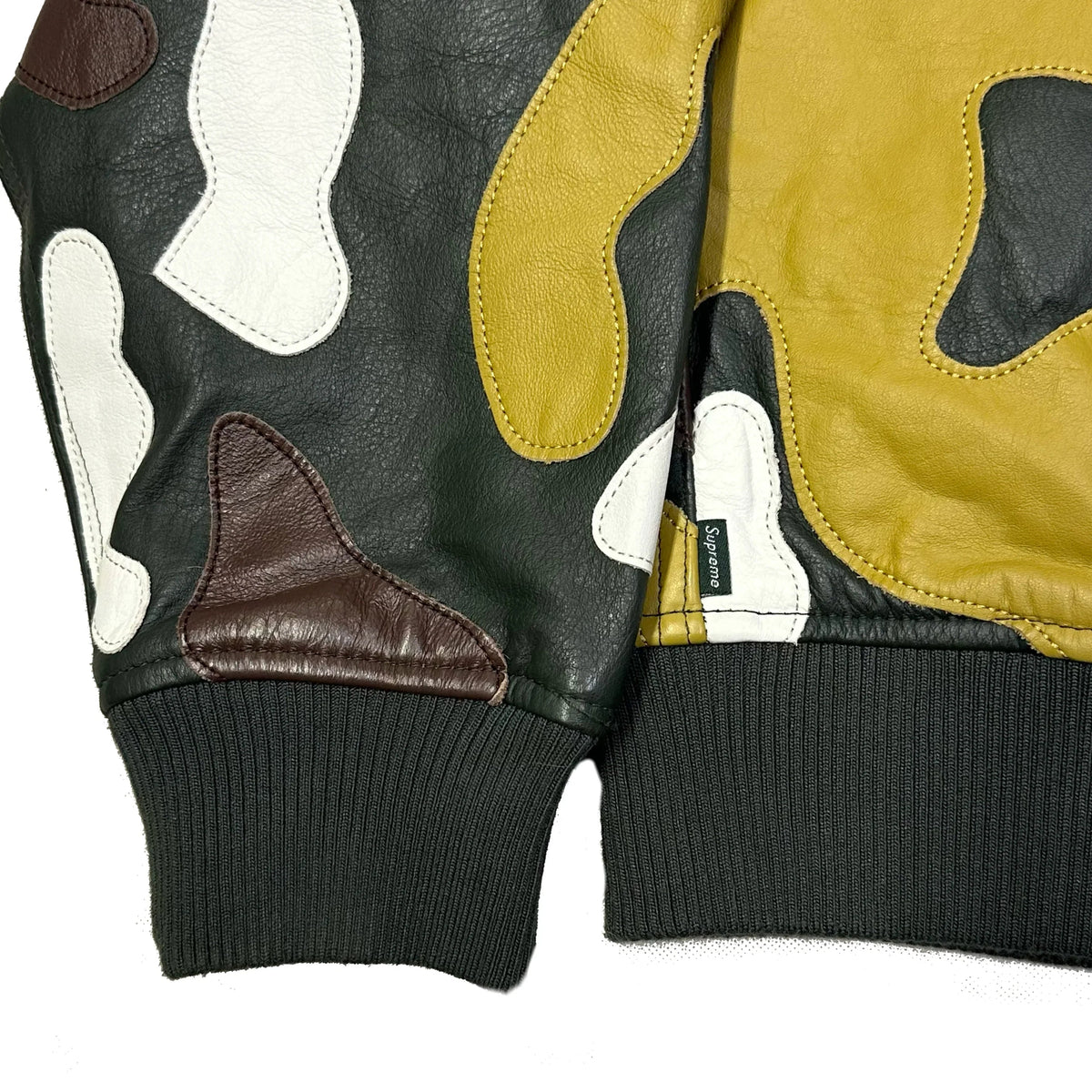 Close-up of a Supreme FW19 Camo Hooded Leather Jacket showing multi-color leather panels.