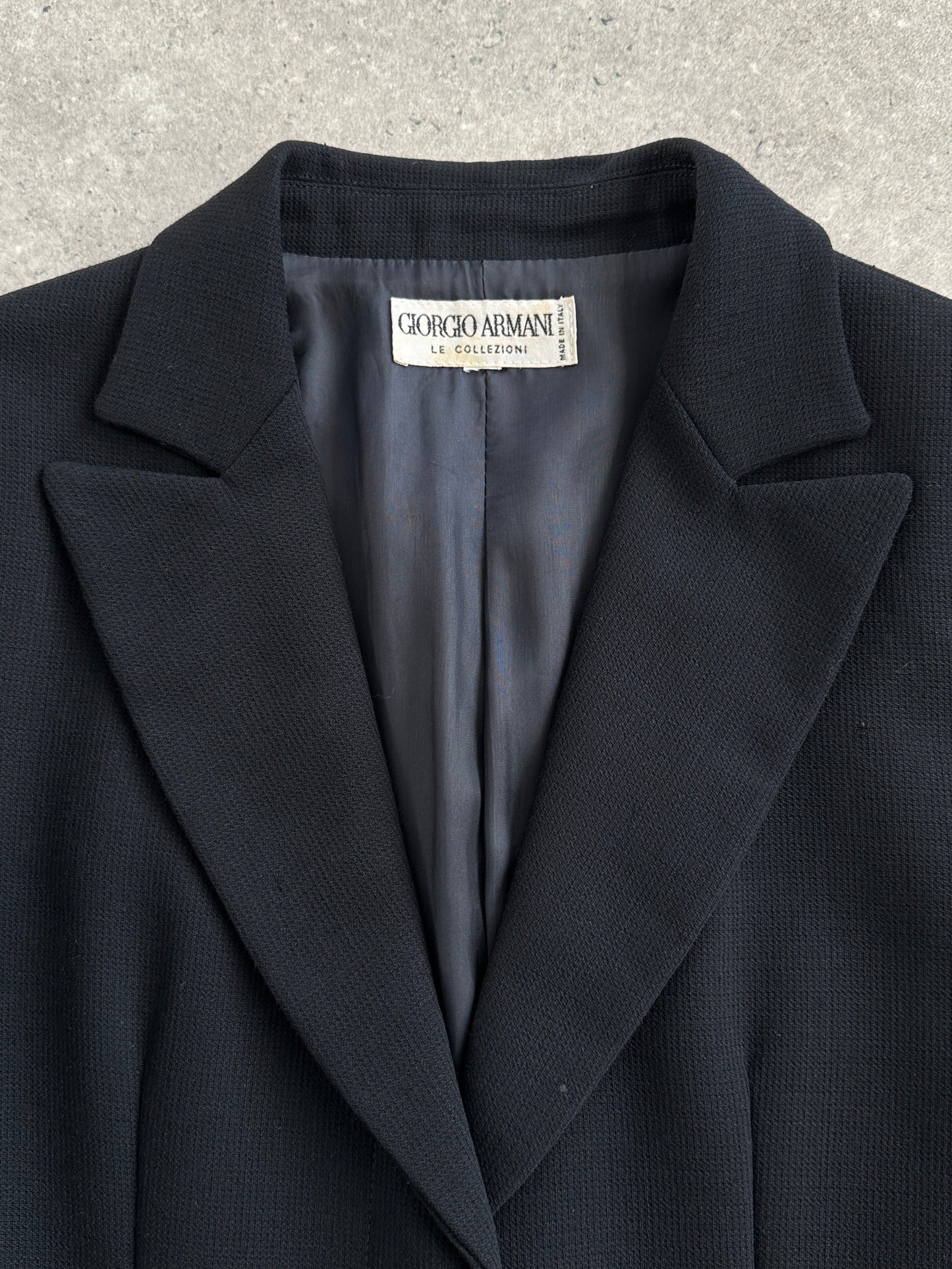 Giorgio Armani Le Collezioni 1990s pure wool single-breasted coat in size S, shown hanging on a wooden hanger.