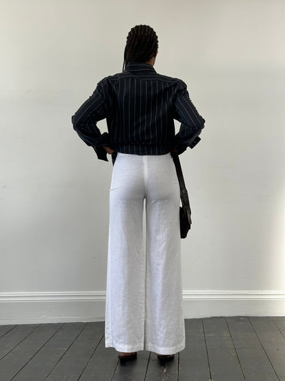 Vintage 1990s pure linen low waist wide-leg trousers in size W24 laid flat with front pockets and relaxed fit.