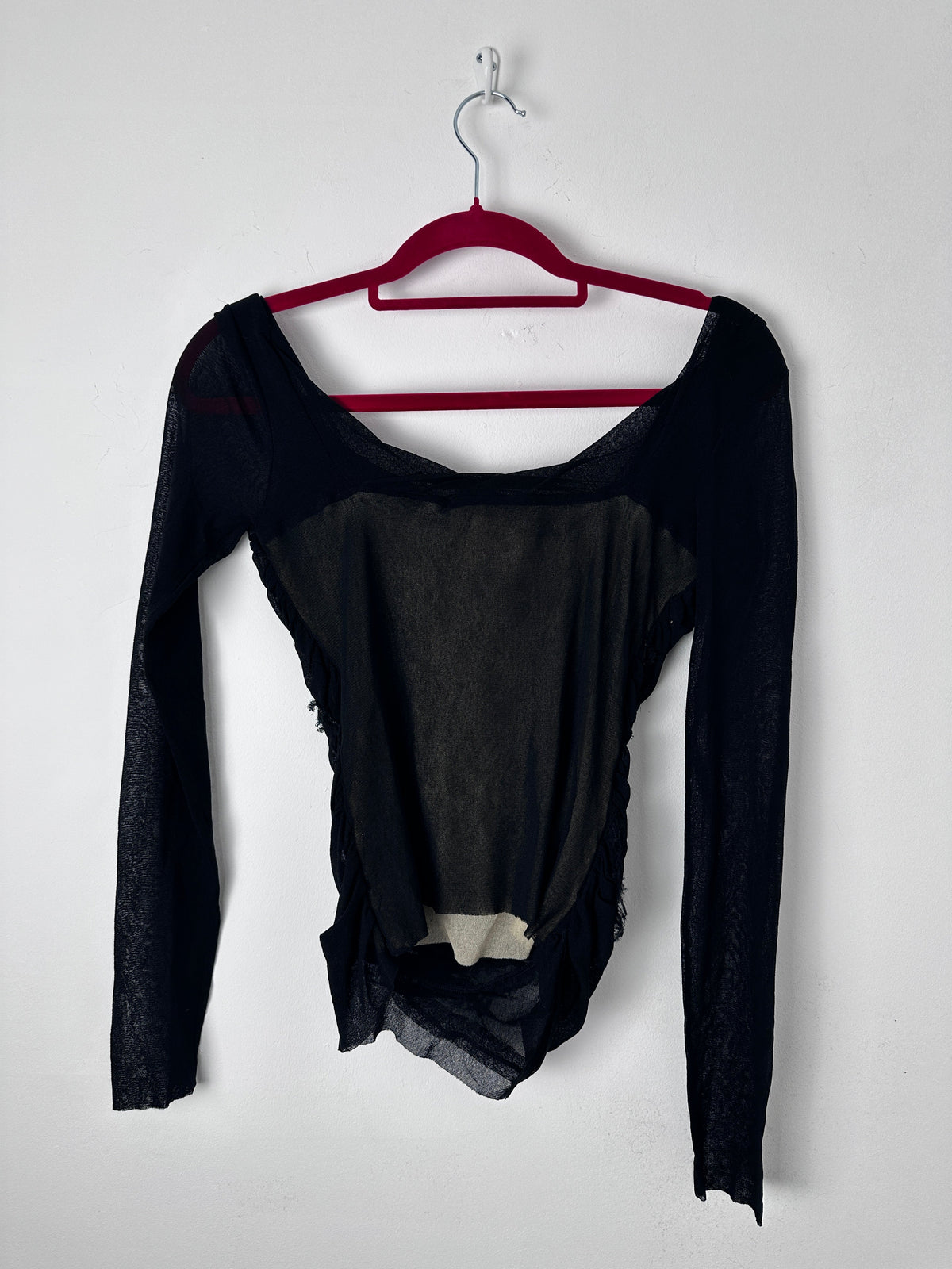 Black top on a red hanger against a white background