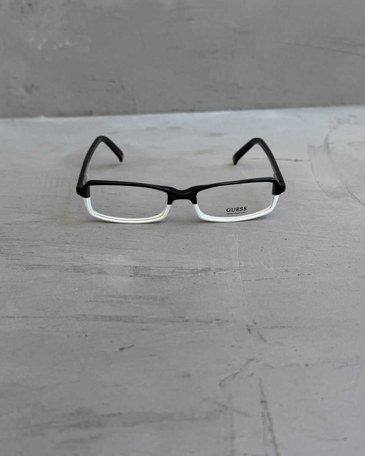Guess Two Tone Black and White Clear Lens Glasses-on a concrete background