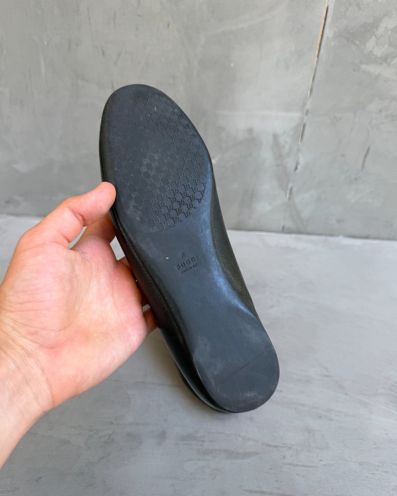 Gucci Black Leather Flats – EU 38-on a concrete background