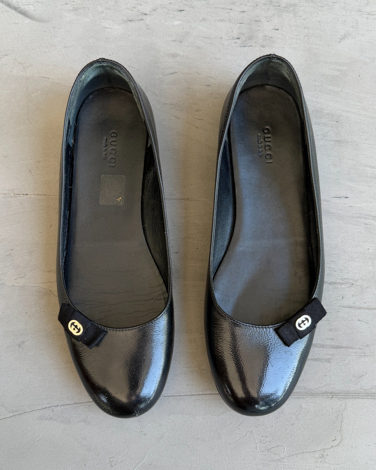 Gucci Black Leather Flats – EU 38-on a concrete background