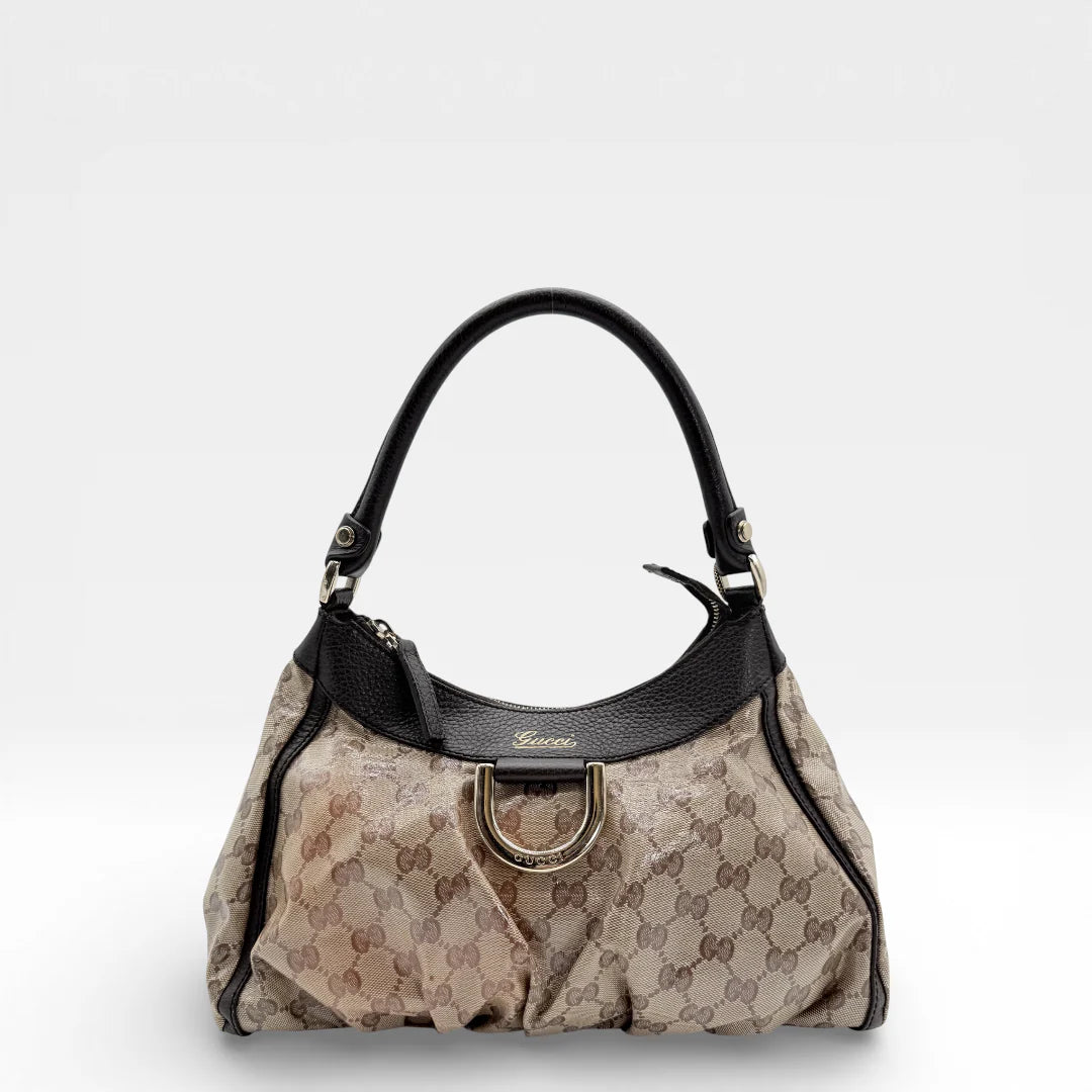https://cdn.shopify.com/s/files/1/0564/9376/8855/files/Gucci_Handtasche_D-Ring_PVC_medium_monogram_beige_vintage_GG_7380.webp?v=1767882588