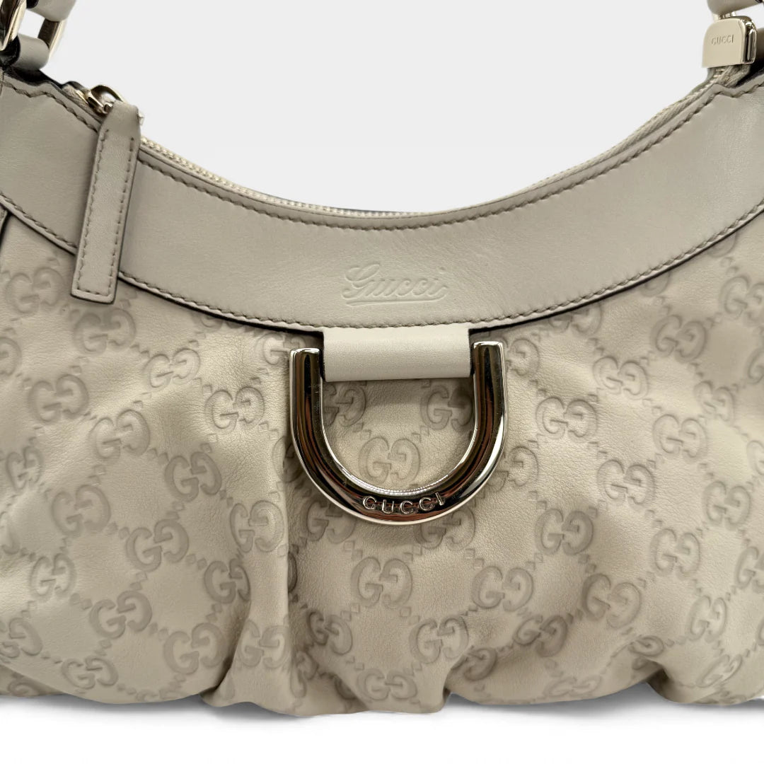 https://cdn.shopify.com/s/files/1/0564/9376/8855/files/Gucci_Handtasche_D-Ring_aus_Leder_monogram_creme___beige_vintage_GG_handbag_5278.webp?v=1765385915
