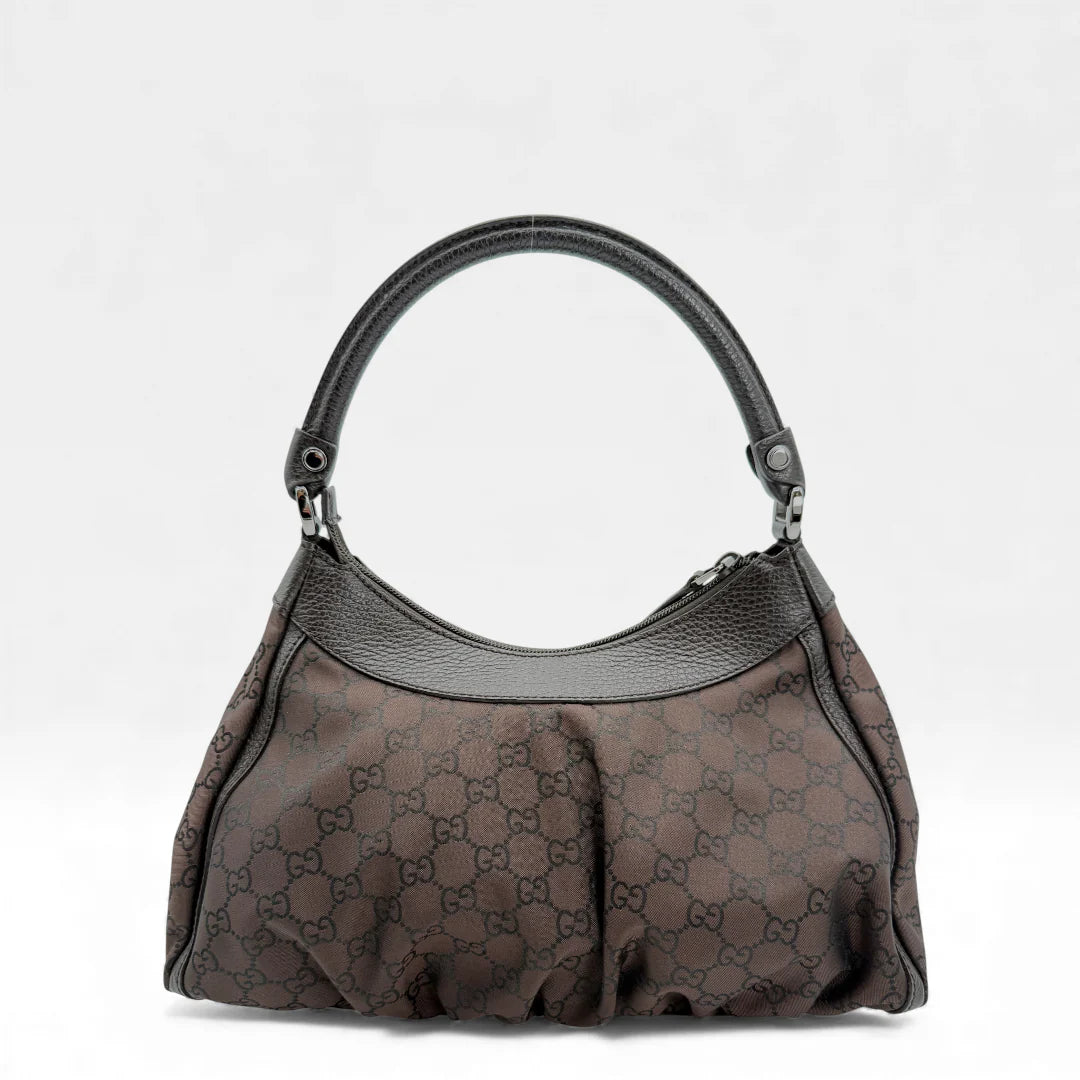 https://cdn.shopify.com/s/files/1/0564/9376/8855/files/Gucci_Handtasche_D-Ring_aus_Nylon_monogram_dunkelbraun_vintage_GG_handbag_5286.webp?v=1765384494