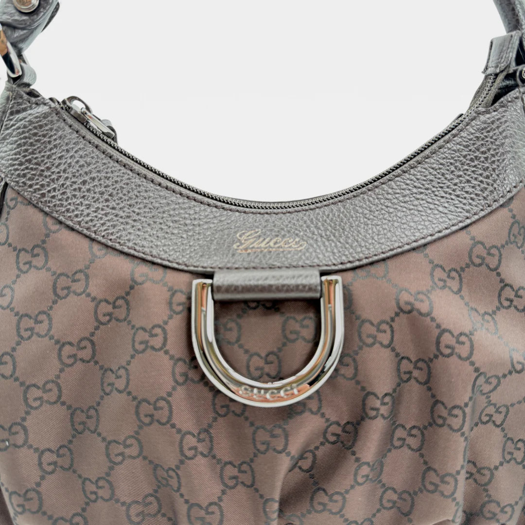 https://cdn.shopify.com/s/files/1/0564/9376/8855/files/Gucci_Handtasche_D-Ring_aus_Nylon_monogram_dunkelbraun_vintage_GG_handbag_5298.webp?v=1765384494