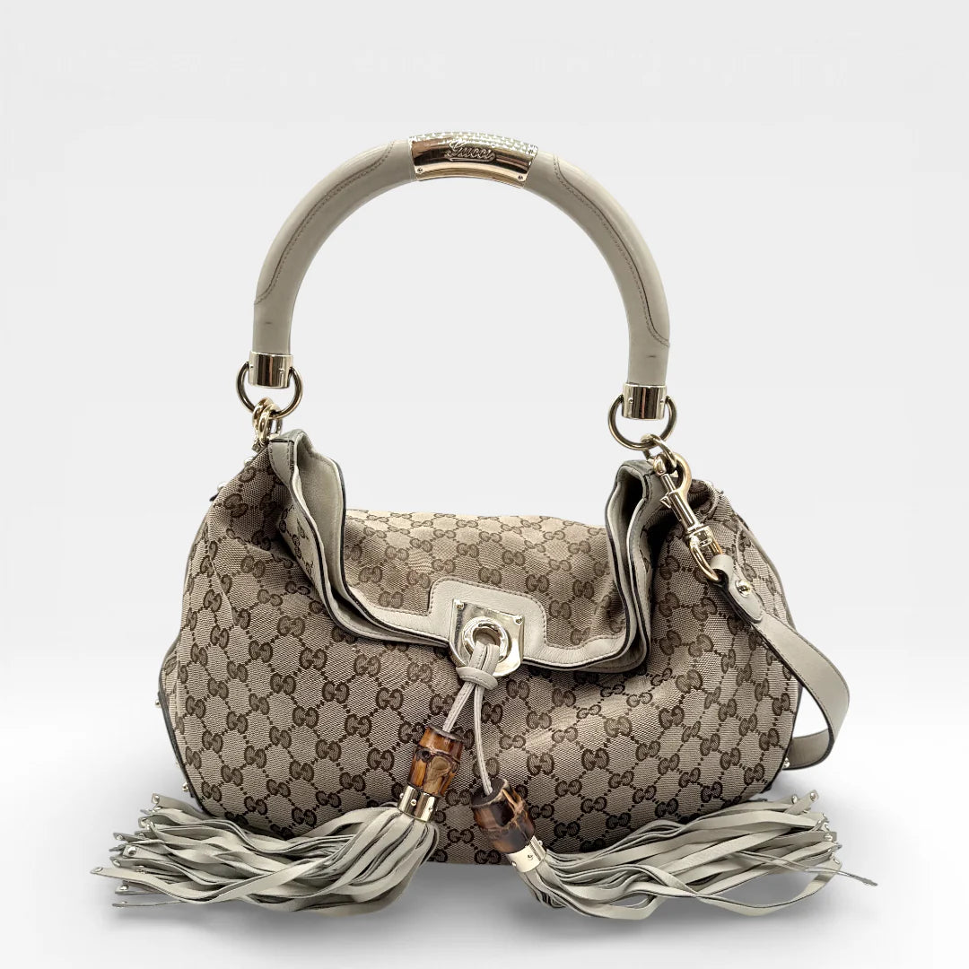 https://cdn.shopify.com/s/files/1/0564/9376/8855/files/Gucci_Handtasche_Indy_mit_Umhaengegurt_monogram_beige_vintage_GG_8641.webp?v=1768480293