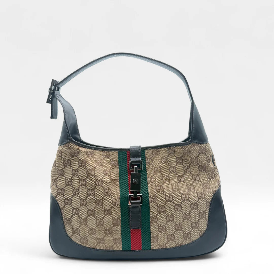 https://cdn.shopify.com/s/files/1/0564/9376/8855/files/Gucci_Handtasche_Jackie_Sherry_Line_monogram_beige_vintage_GG_handbag9482.webp?v=1760530502