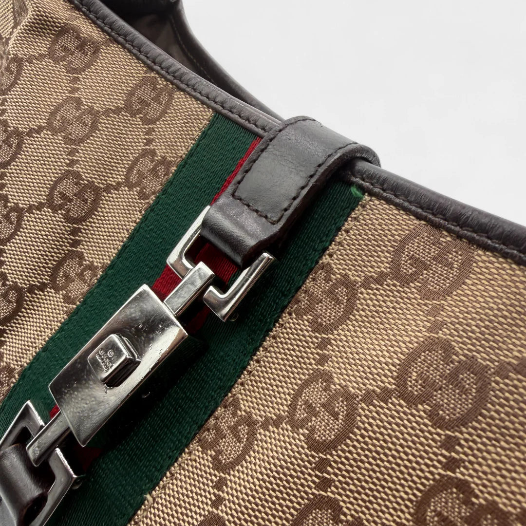https://cdn.shopify.com/s/files/1/0564/9376/8855/files/Gucci_Handtasche_Jackie_Sherry_Line_monogram_beige_vintage_GG_handbag9499.webp?v=1760701865