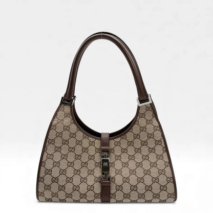 https://cdn.shopify.com/s/files/1/0564/9376/8855/files/Gucci_Handtasche_Jackie_monogram_beige_vintage_GG_handbag_5304.webp?v=1765384605
