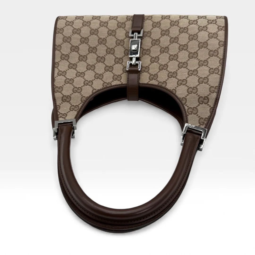https://cdn.shopify.com/s/files/1/0564/9376/8855/files/Gucci_Handtasche_Jackie_monogram_beige_vintage_GG_handbag_5314.webp?v=1765384622