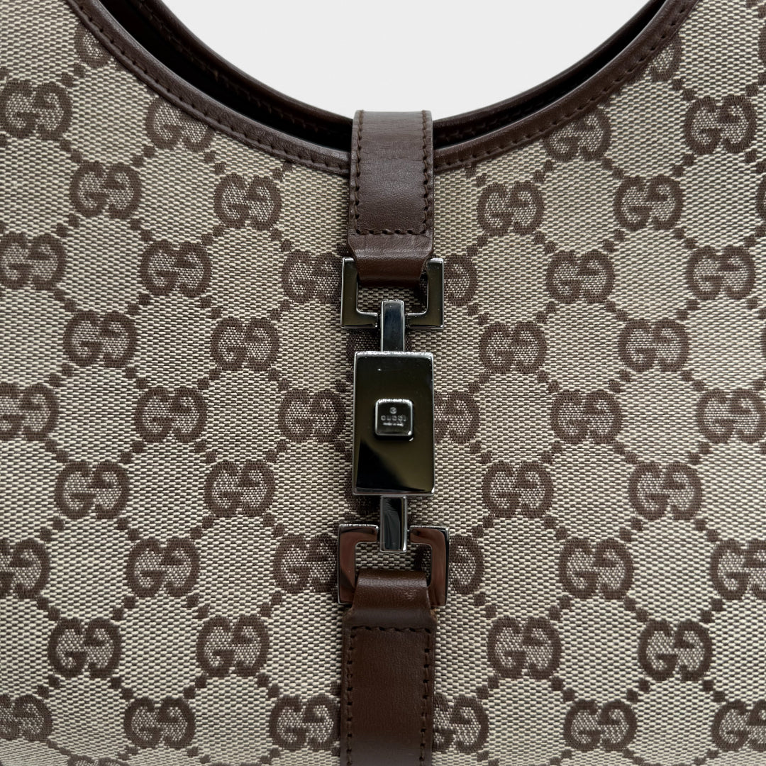 https://cdn.shopify.com/s/files/1/0564/9376/8855/files/Gucci_Handtasche_Jackie_monogram_beige_vintage_GG_handbag_5315.webp?v=1765384622