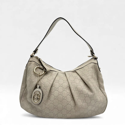 https://cdn.shopify.com/s/files/1/0564/9376/8855/files/Gucci_Handtasche_Sukey_One_aus_Leder_monogram_beige_vintage_GG_handbag_5216.webp?v=1765382538