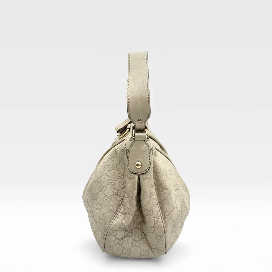 https://cdn.shopify.com/s/files/1/0564/9376/8855/files/Gucci_Handtasche_Sukey_One_aus_Leder_monogram_beige_vintage_GG_handbag_5219.webp?v=1765382584