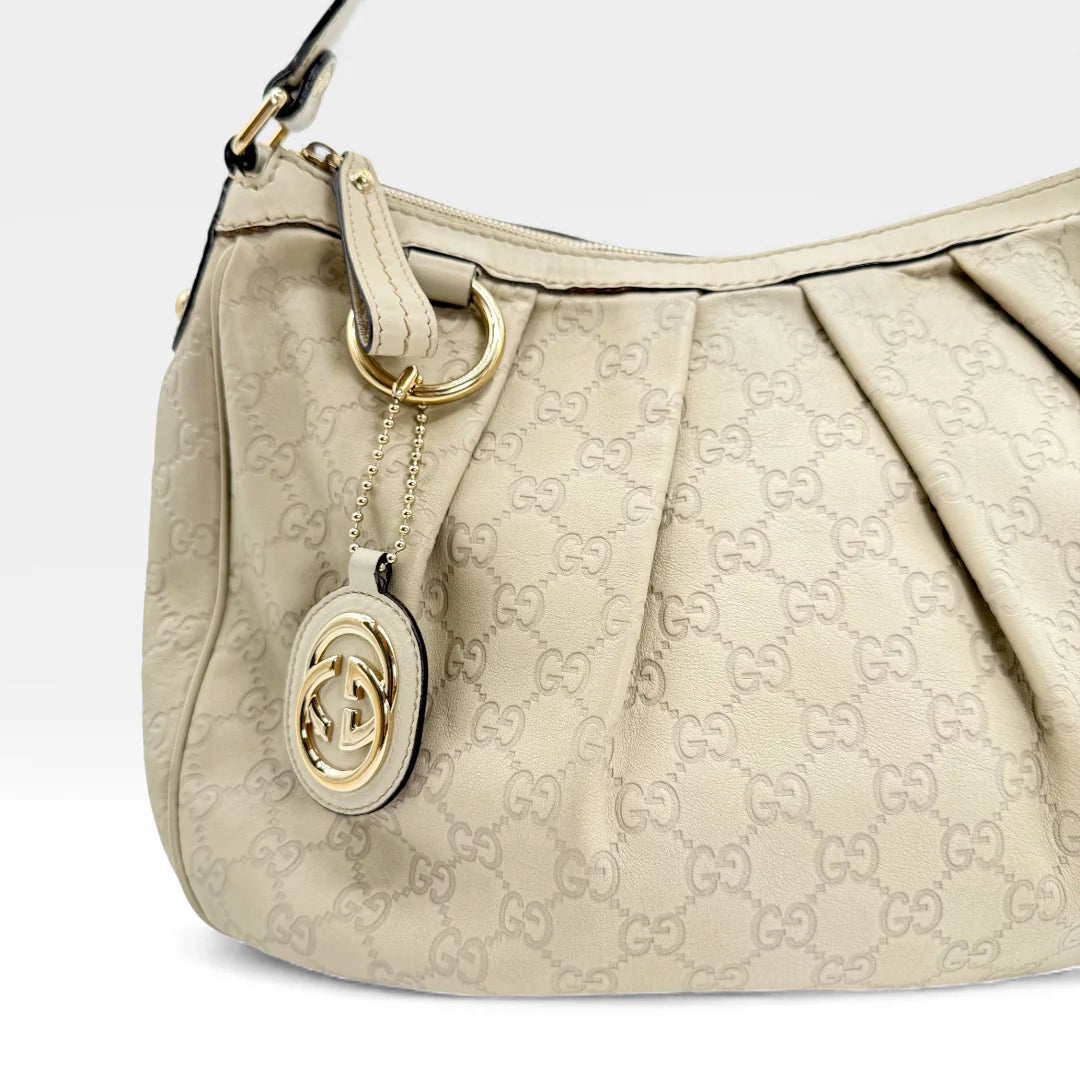 https://cdn.shopify.com/s/files/1/0564/9376/8855/files/Gucci_Handtasche_Sukey_One_aus_Leder_monogram_beige_vintage_GG_handbag_5226.webp?v=1765382584
