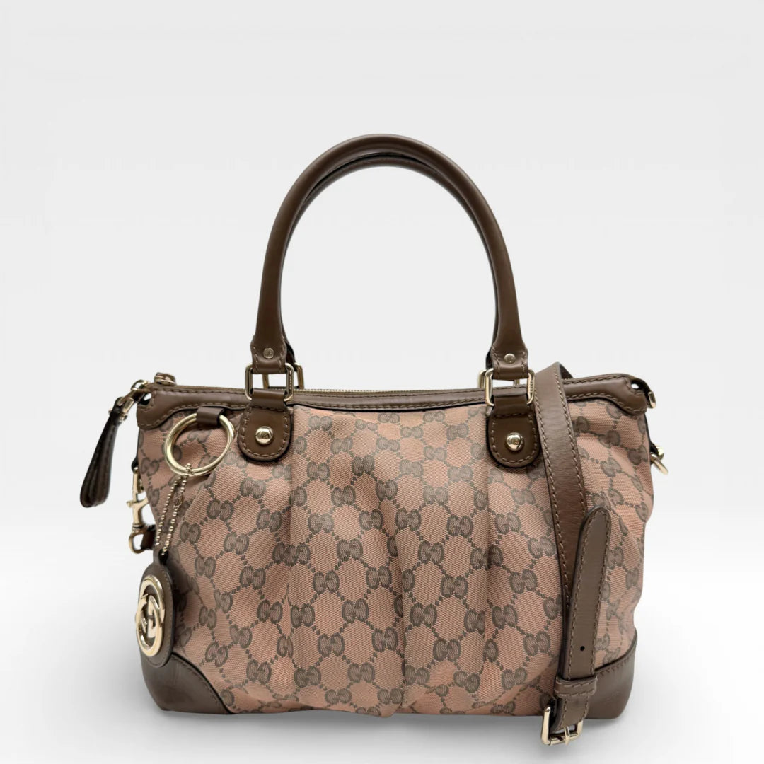 https://cdn.shopify.com/s/files/1/0564/9376/8855/files/Gucci_Handtasche_Sukey_mit_Umhaengegurt_monogram_braun_vintage_GG_8730.webp?v=1769118088