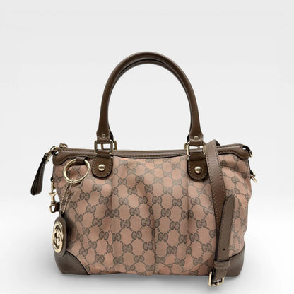 https://cdn.shopify.com/s/files/1/0564/9376/8855/files/Gucci_Handtasche_Sukey_mit_Umhaengegurt_monogram_braun_vintage_GG_8730.webp?v=1769118088
