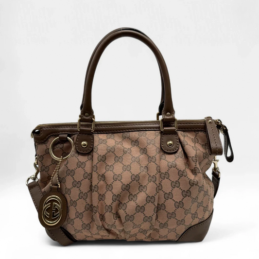 https://cdn.shopify.com/s/files/1/0564/9376/8855/files/Gucci_Handtasche_Sukey_mit_Umhangegurt_braun_vintage_designer_GG_handbag3506.webp?v=1757508150