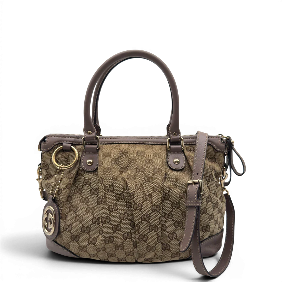 https://cdn.shopify.com/s/files/1/0564/9376/8855/files/Gucci_Handtasche_Sukey_mit_Umhangegurt_monogram_beige_1.webp?v=1782909395