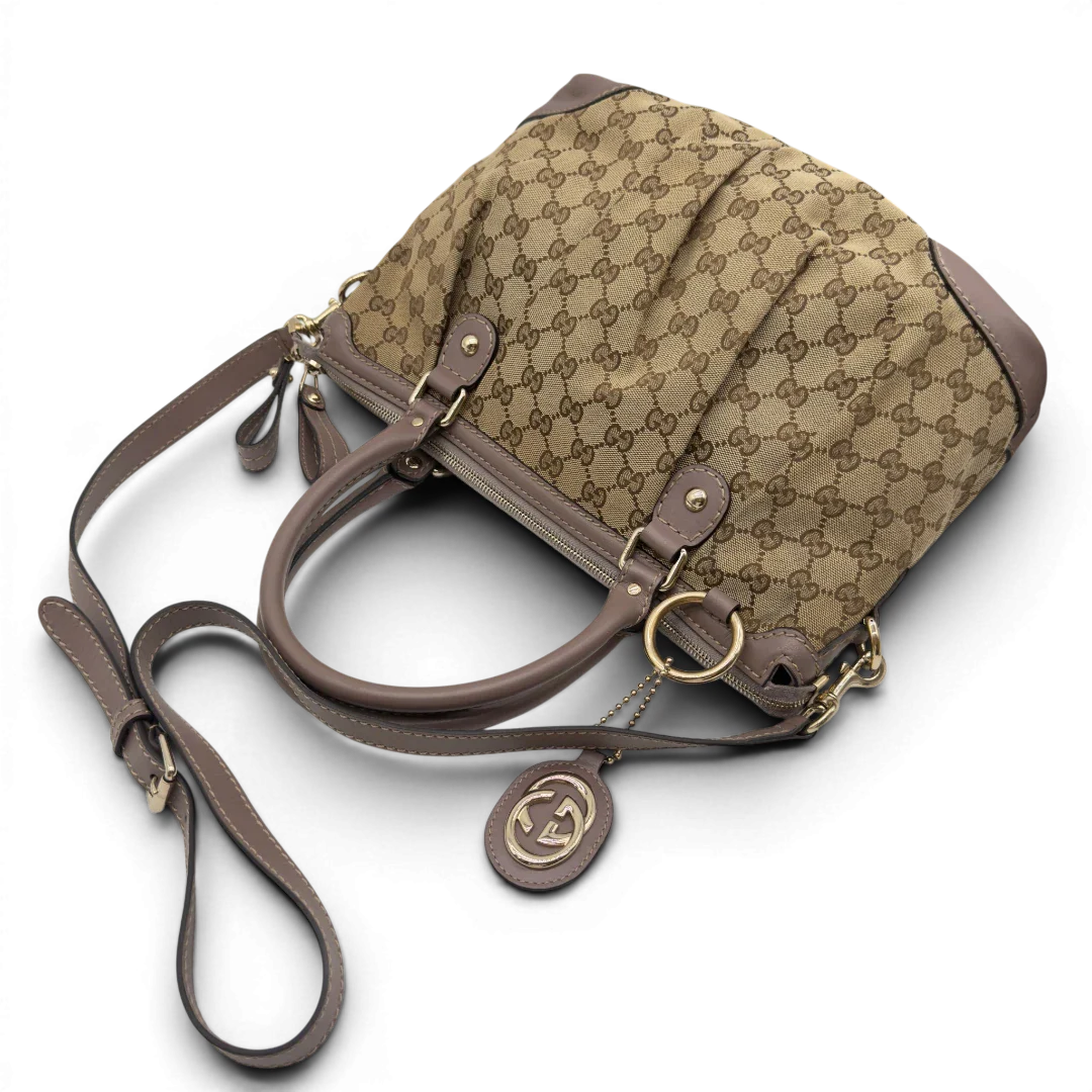 https://cdn.shopify.com/s/files/1/0564/9376/8855/files/Gucci_Handtasche_Sukey_mit_Umhangegurt_monogram_beige_10.webp?v=1782909396