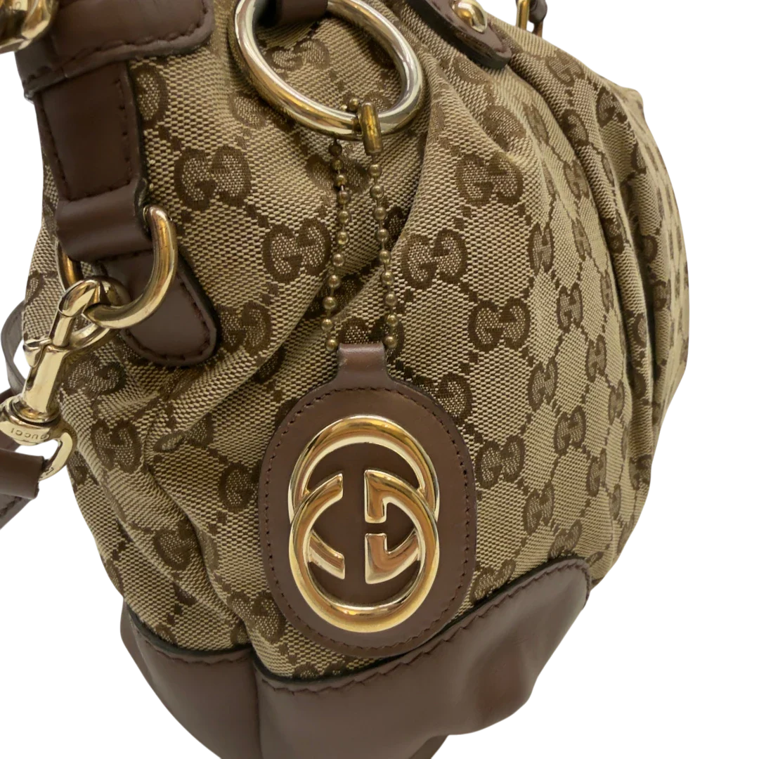 https://cdn.shopify.com/s/files/1/0564/9376/8855/files/Gucci_Handtasche_Sukey_mit_Umhangegurt_monogram_beige_12_3e34c9cc-b003-4e19-a776-3f87f9cdda92.webp?v=1783513163