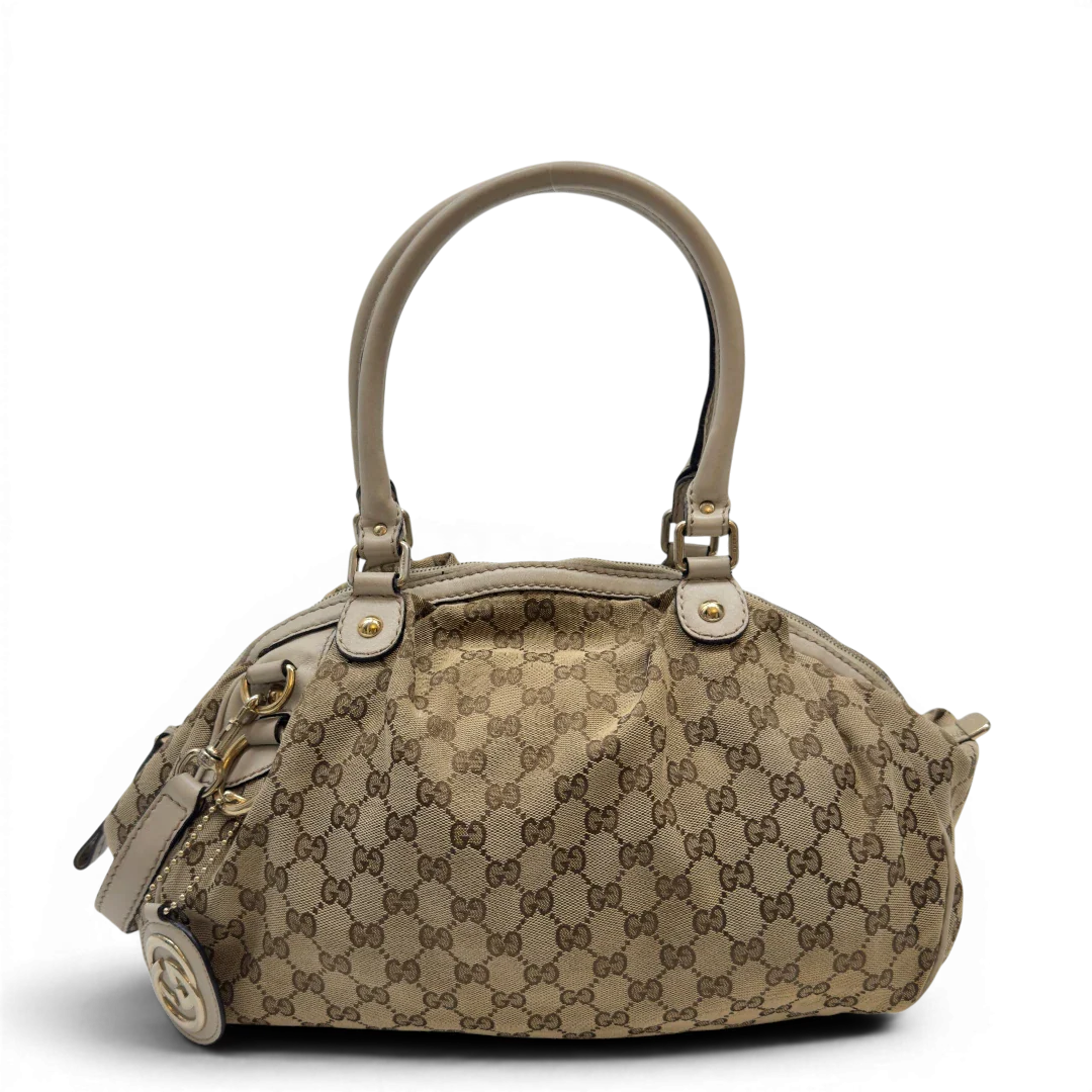 https://cdn.shopify.com/s/files/1/0564/9376/8855/files/Gucci_Handtasche_Sukey_mit_Umhangegurt_monogram_beige_1_bf078dec-4c6f-4b7e-92f4-6b265bf02e87.webp?v=1783513326