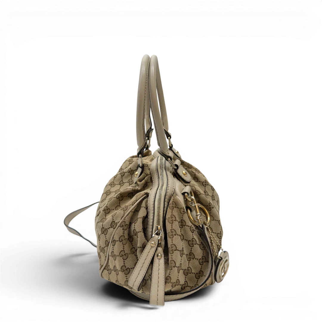 https://cdn.shopify.com/s/files/1/0564/9376/8855/files/Gucci_Handtasche_Sukey_mit_Umhangegurt_monogram_beige_2_19ce3414-ea12-4c2b-83d1-9b0126046b51.webp?v=1783513326