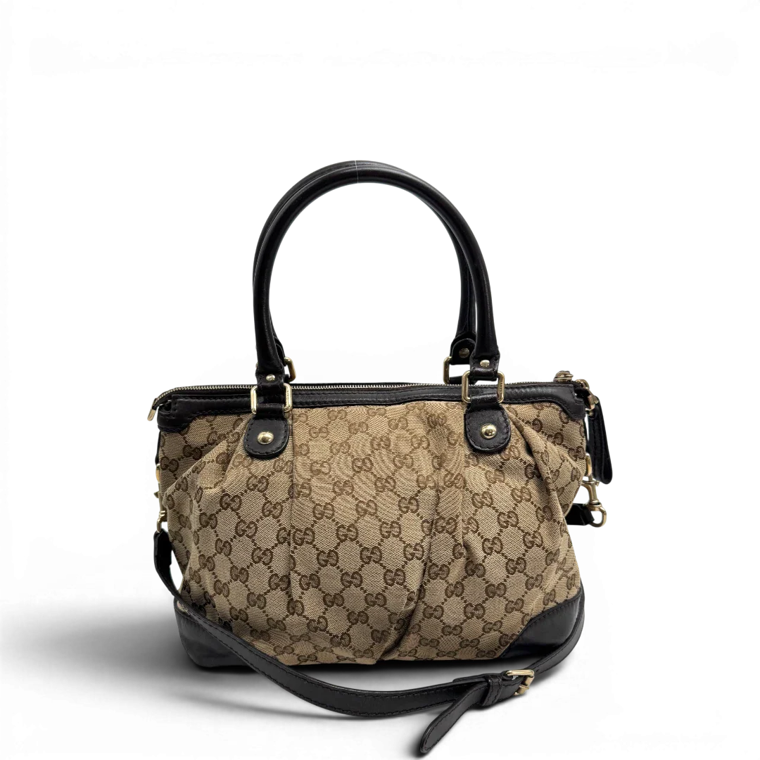 https://cdn.shopify.com/s/files/1/0564/9376/8855/files/Gucci_Handtasche_Sukey_mit_Umhangegurt_monogram_beige_vintage_GG2327.webp?v=1779968392
