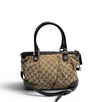 https://cdn.shopify.com/s/files/1/0564/9376/8855/files/Gucci_Handtasche_Sukey_mit_Umhangegurt_monogram_beige_vintage_GG2327.webp?v=1779968392