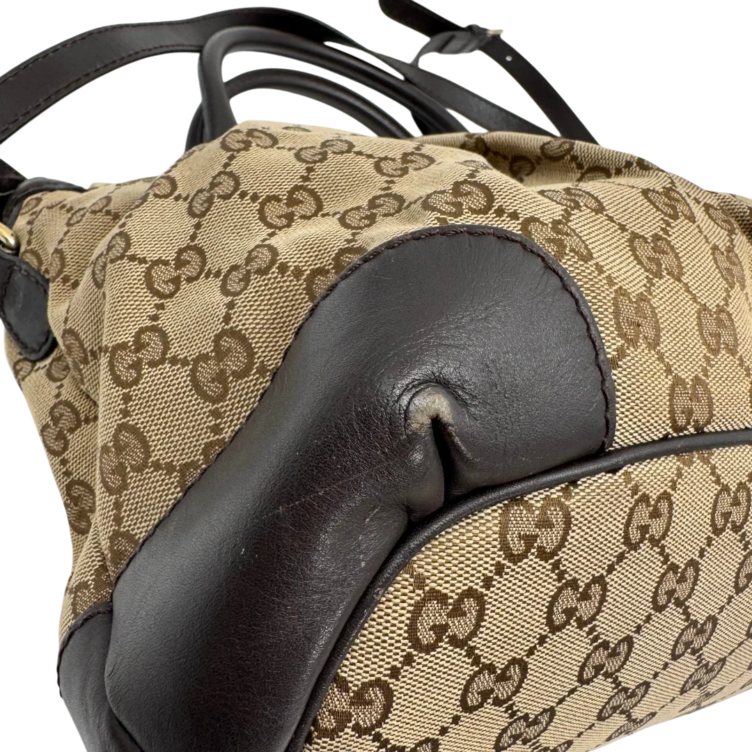 https://cdn.shopify.com/s/files/1/0564/9376/8855/files/Gucci_Handtasche_Sukey_mit_Umhangegurt_monogram_beige_vintage_GG2331.webp?v=1779968393