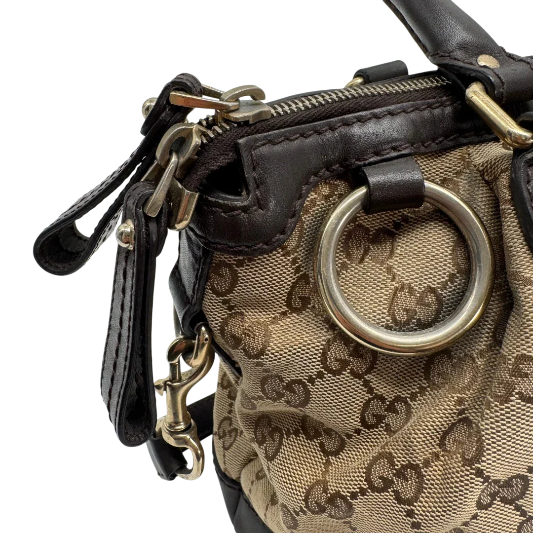 https://cdn.shopify.com/s/files/1/0564/9376/8855/files/Gucci_Handtasche_Sukey_mit_Umhangegurt_monogram_beige_vintage_GG2335.webp?v=1779968392