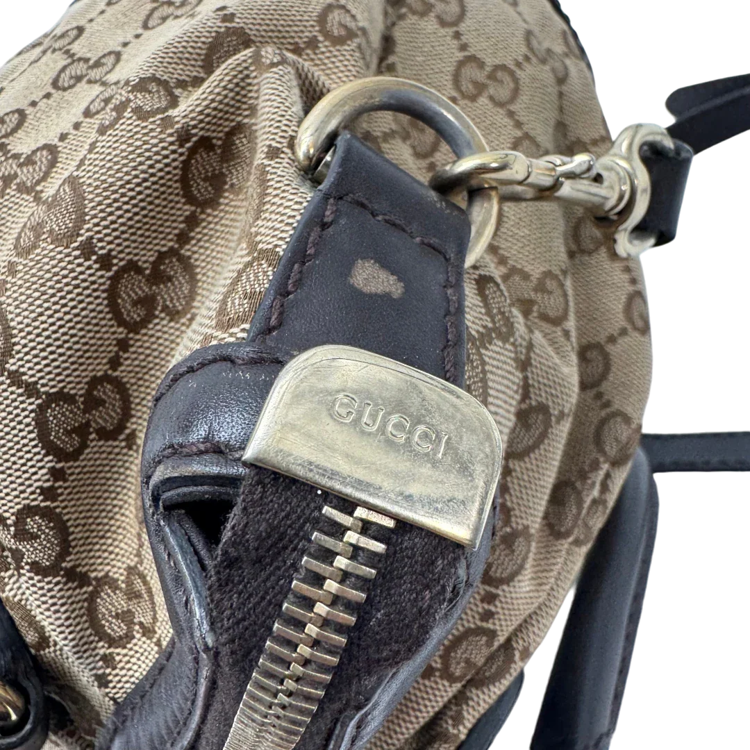 https://cdn.shopify.com/s/files/1/0564/9376/8855/files/Gucci_Handtasche_Sukey_mit_Umhangegurt_monogram_beige_vintage_GG2337.webp?v=1779968392