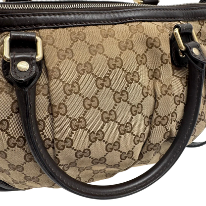 https://cdn.shopify.com/s/files/1/0564/9376/8855/files/Gucci_Handtasche_Sukey_mit_Umhangegurt_monogram_beige_vintage_GG2338.webp?v=1779968393