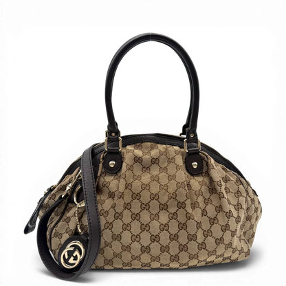 https://cdn.shopify.com/s/files/1/0564/9376/8855/files/Gucci_Handtasche_Sukey_mit_Umhangegurt_monogram_beige_vintage_GG6104.webp?v=1775065489