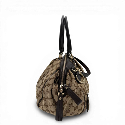 https://cdn.shopify.com/s/files/1/0564/9376/8855/files/Gucci_Handtasche_Sukey_mit_Umhangegurt_monogram_beige_vintage_GG6107.webp?v=1775065519