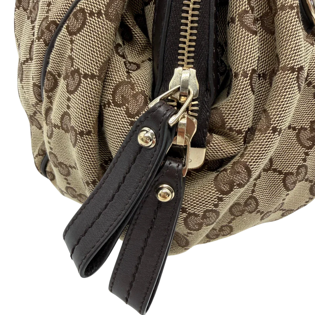 https://cdn.shopify.com/s/files/1/0564/9376/8855/files/Gucci_Handtasche_Sukey_mit_Umhangegurt_monogram_beige_vintage_GG6115.webp?v=1775065519