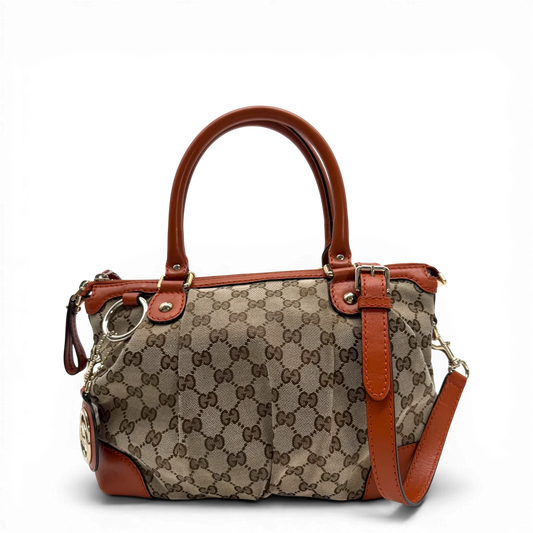 https://cdn.shopify.com/s/files/1/0564/9376/8855/files/Gucci_Handtasche_Sukey_mit_Umhangegurt_monogram_beige_vintage_GG6239.webp?v=1775057961