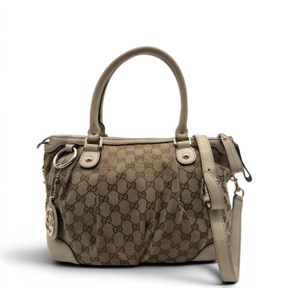 https://cdn.shopify.com/s/files/1/0564/9376/8855/files/Gucci_Handtasche_Sukey_mit_Umhangegurt_monogram_beige_vintage_GG7928.webp?v=1779966403