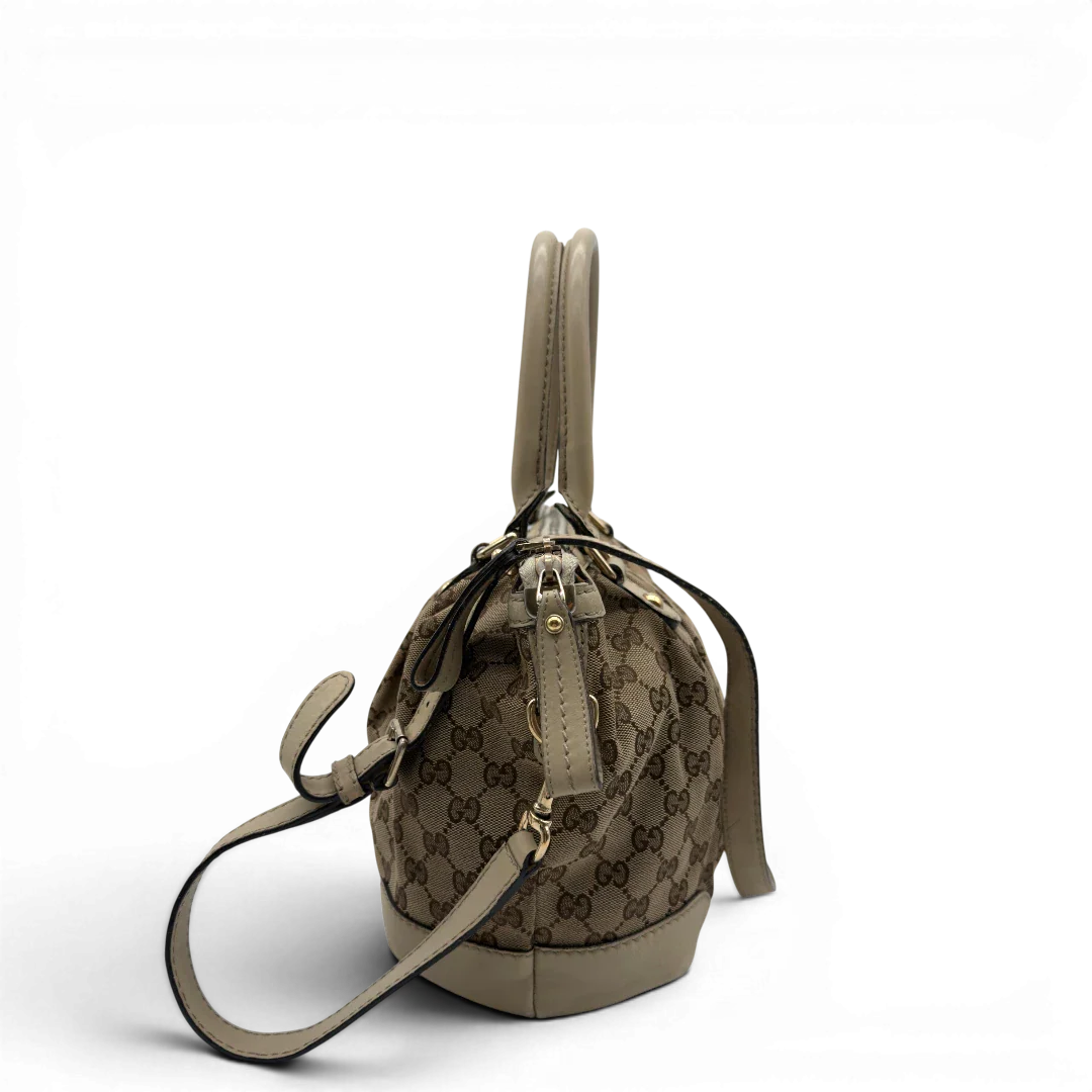 https://cdn.shopify.com/s/files/1/0564/9376/8855/files/Gucci_Handtasche_Sukey_mit_Umhangegurt_monogram_beige_vintage_GG7930.webp?v=1779966402