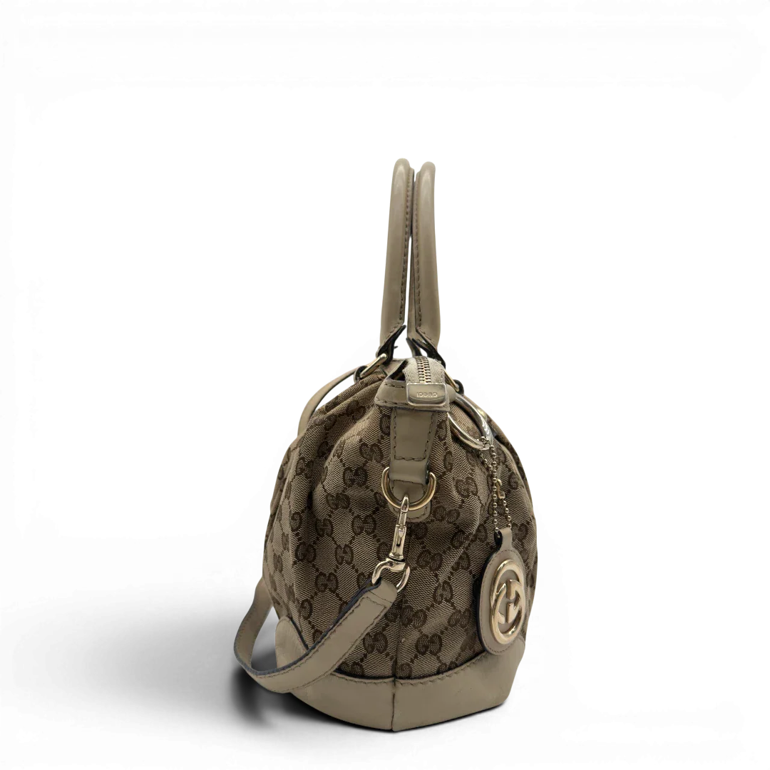 https://cdn.shopify.com/s/files/1/0564/9376/8855/files/Gucci_Handtasche_Sukey_mit_Umhangegurt_monogram_beige_vintage_GG7931.webp?v=1779966402