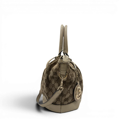 https://cdn.shopify.com/s/files/1/0564/9376/8855/files/Gucci_Handtasche_Sukey_mit_Umhangegurt_monogram_beige_vintage_GG7931.webp?v=1779966402